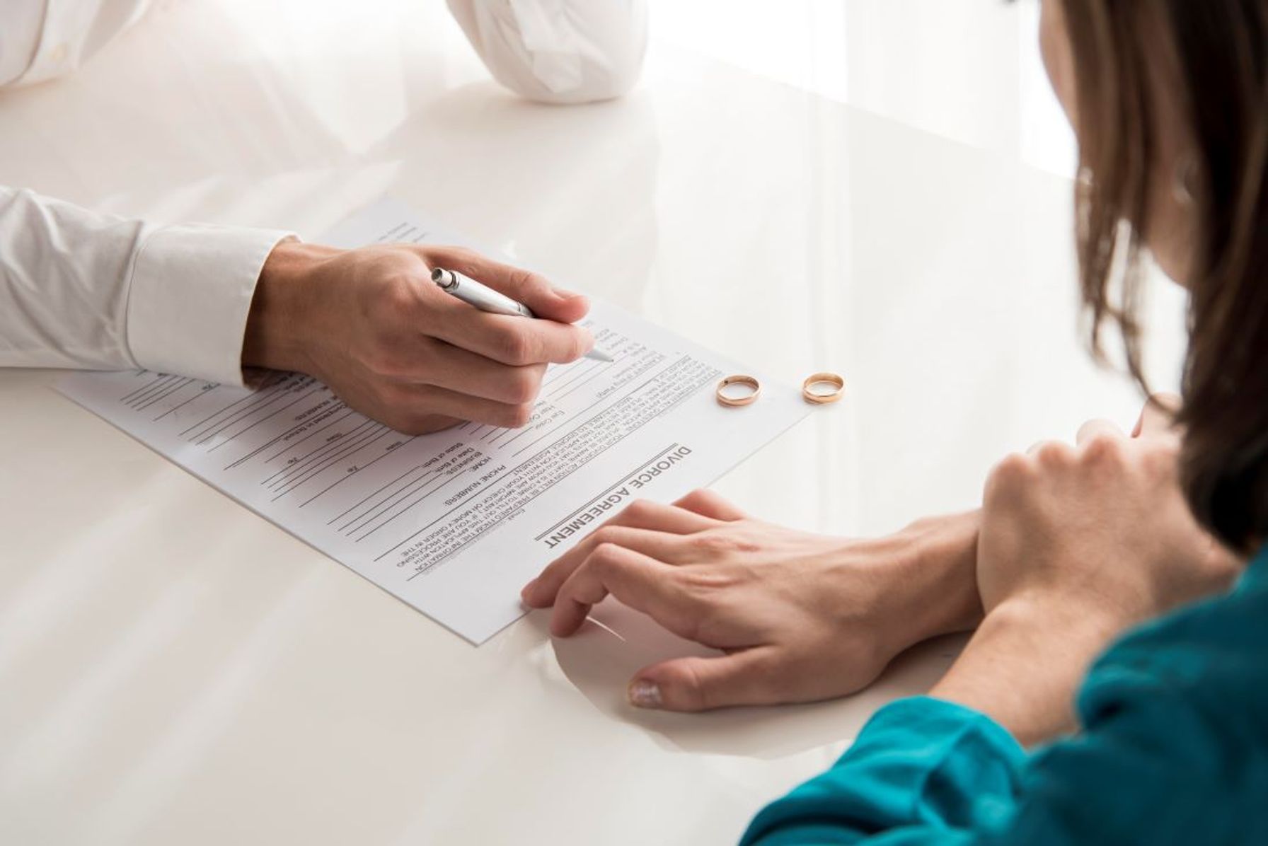 Close-up of a couple sitting apart with tense expressions, symbolizing emotional strain during divorce.